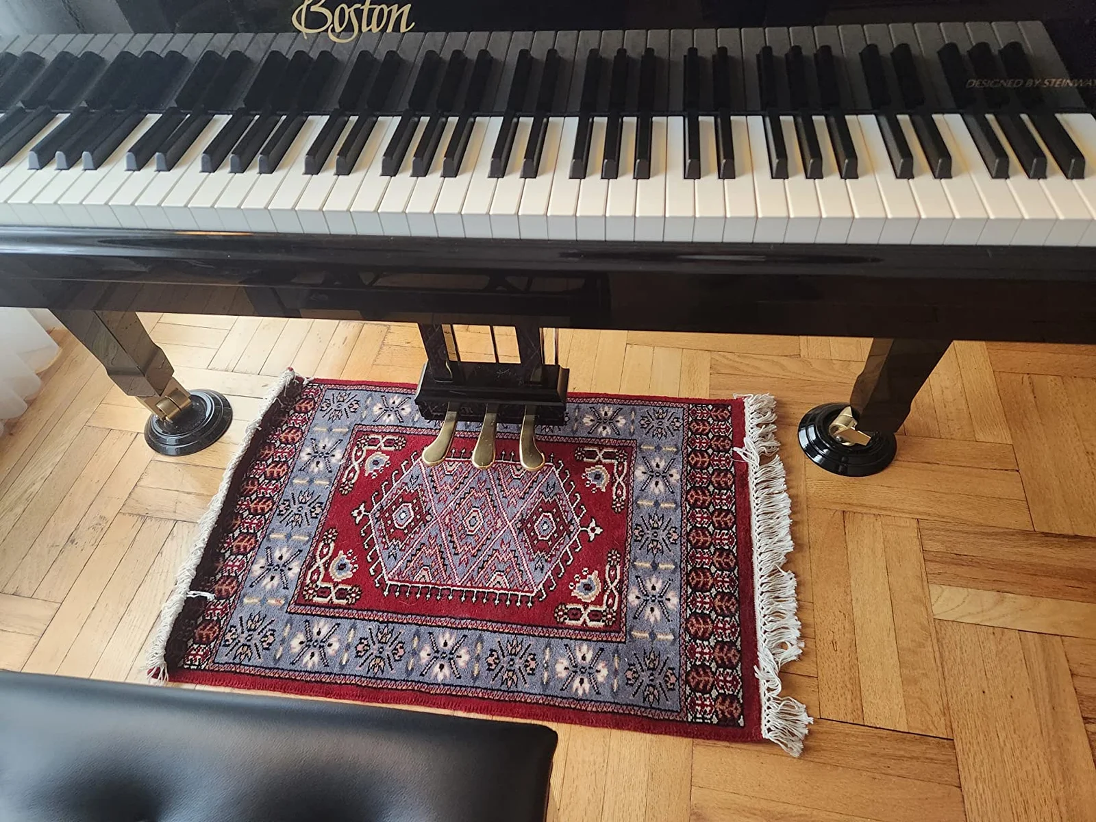 Amma Carpets hand knotted red rug under the piano